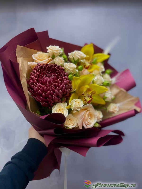 Этот утончённый букет сочетает элегантность хризантемы бигуди с изысканной грацией орхидеи, создавая