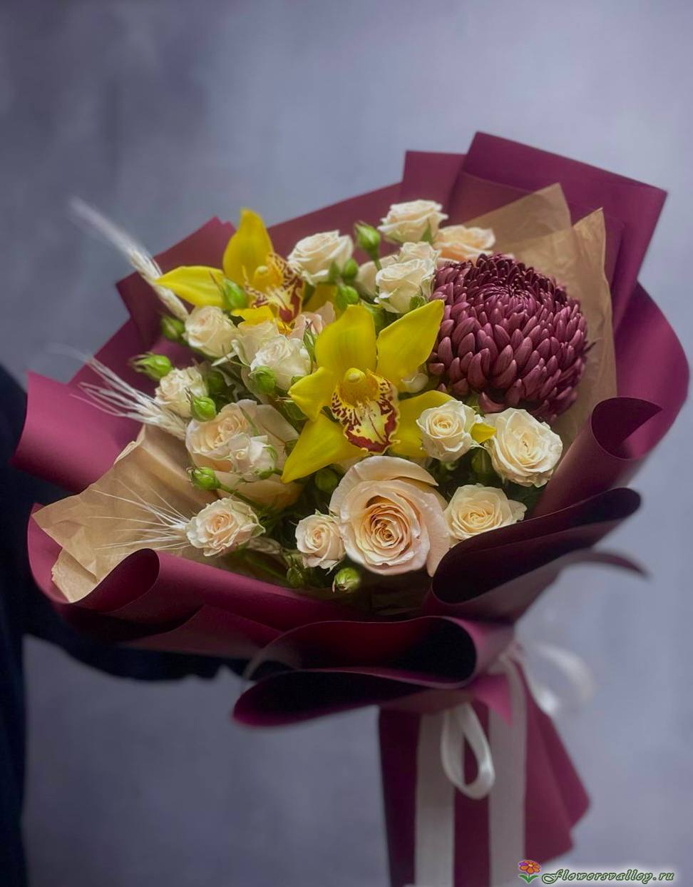 Этот утончённый букет сочетает элегантность хризантемы бигуди с изысканной грацией орхидеи, создавая